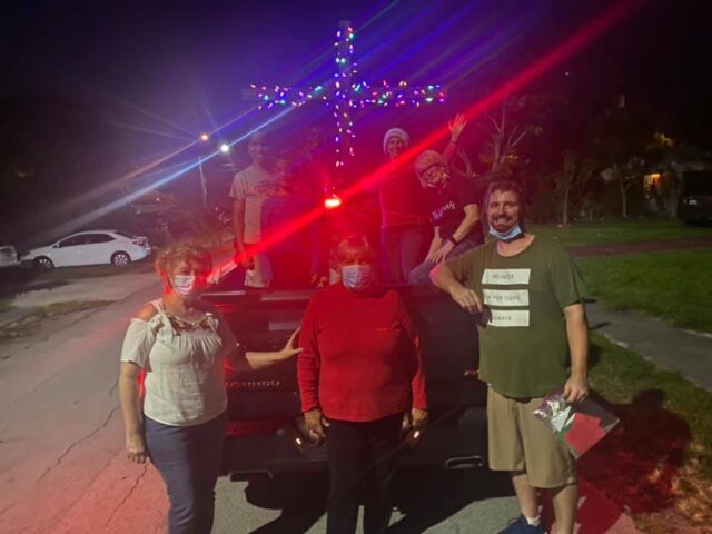 Group with lighted cross at night.