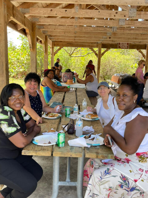 People enjoying a picnic under a pavilion.