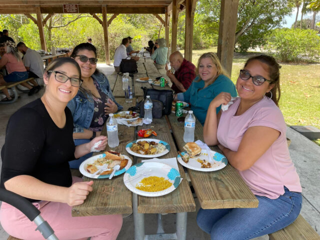 People enjoying a picnic under a shelter.