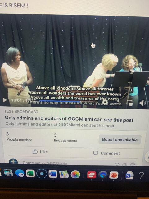 Three women singing on stage with microphones.