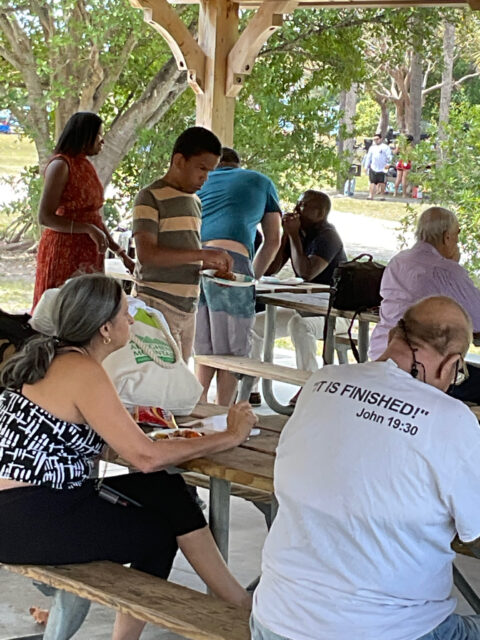 People gathered under a park pavilion.