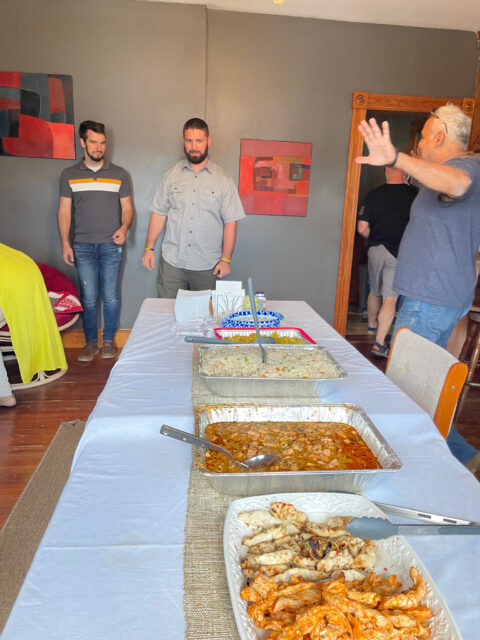 People gathered around table with food trays.