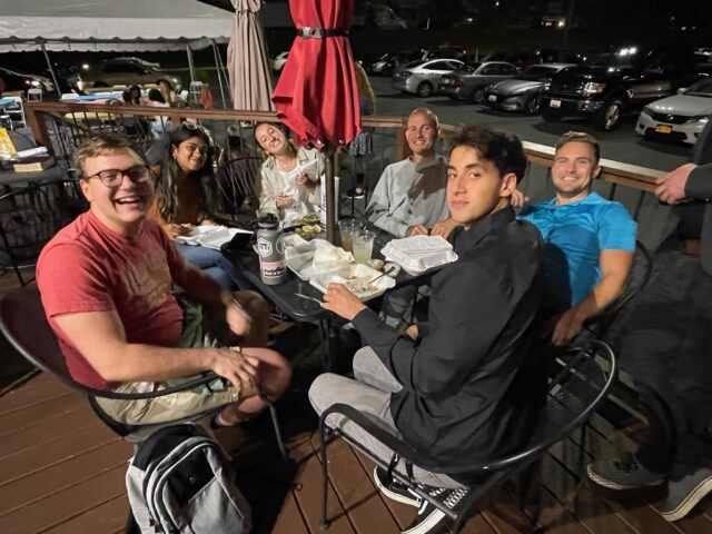 Group of friends dining outdoors at night.
