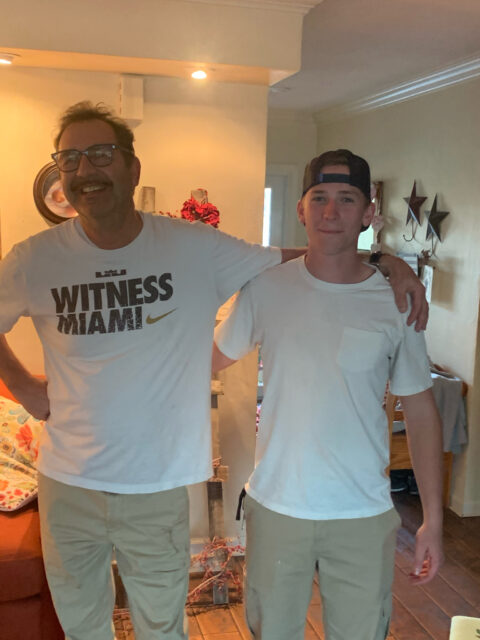 Two people smiling in a living room.