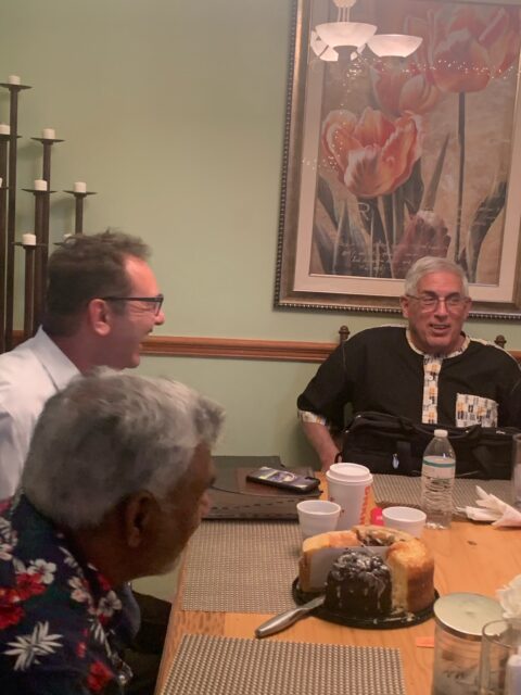Group of people dining and chatting indoors.
