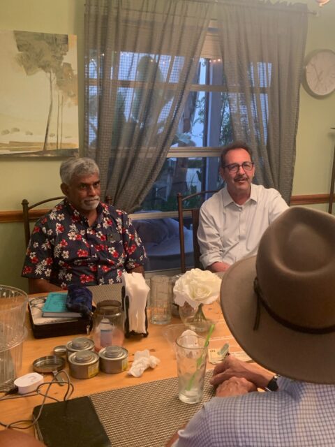 Three people sitting around a dining table.