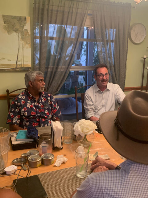 People sitting around a dining table talking.