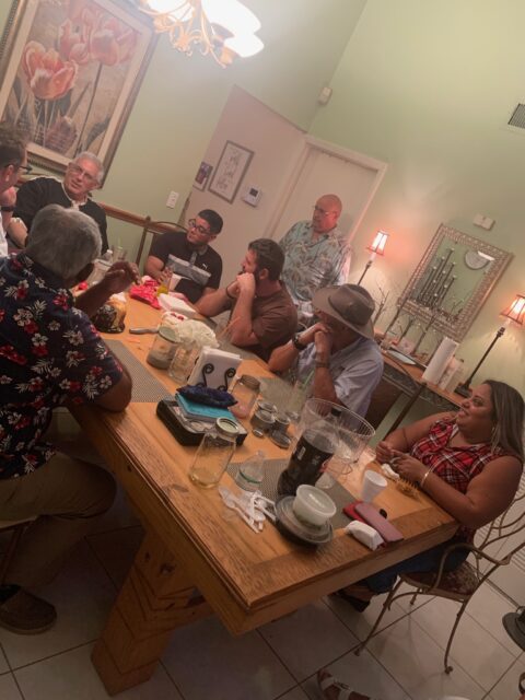 People gathered around a dining table talking.