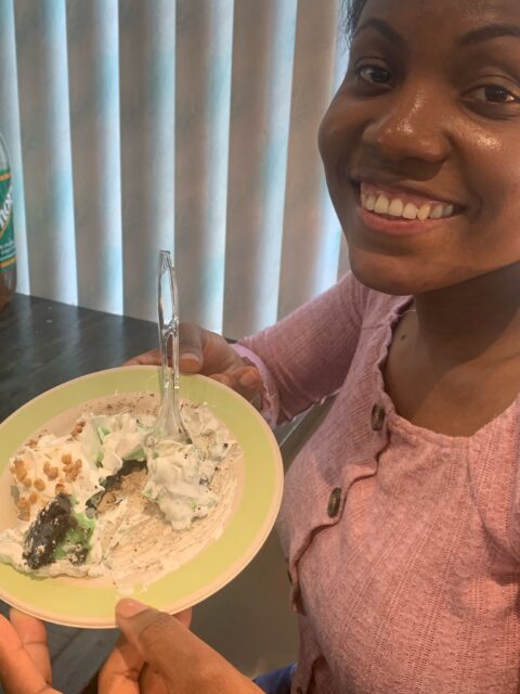 Smiling person holding a dessert plate.