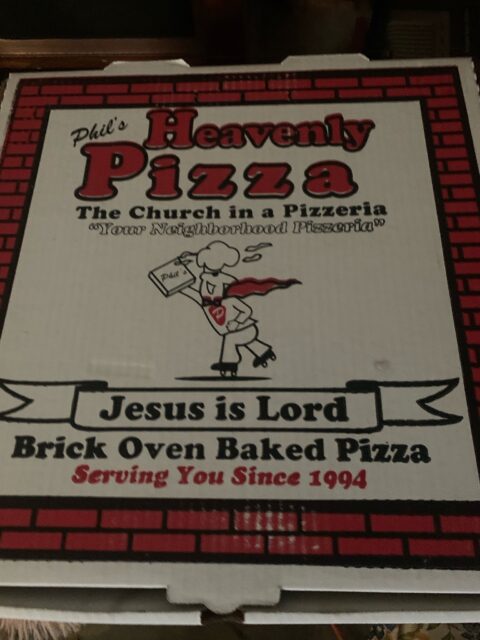 Pizza box with religious-themed branding.