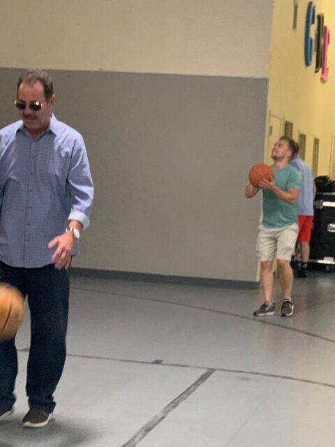 Two men playing basketball indoors.