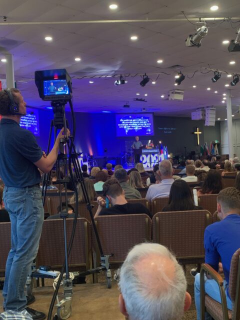 Camera operator filming a church service event.