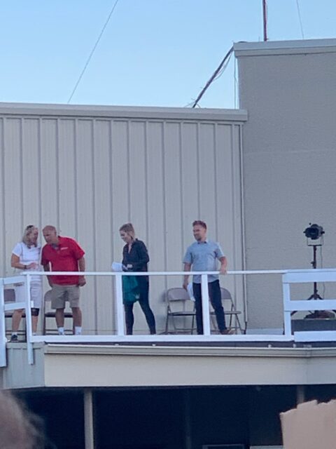People standing on a rooftop platform.