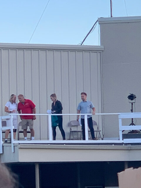 People standing on a rooftop platform.