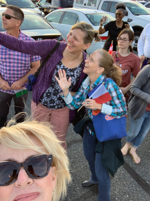 Group of people smiling and taking photos.