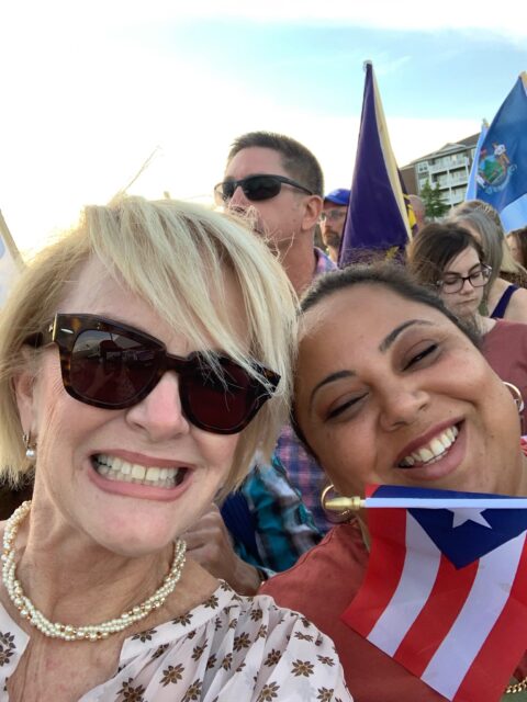 Two women smiling with a Puerto Rican flag.