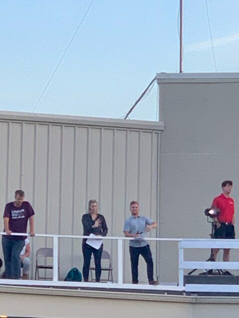 People standing on a rooftop platform.