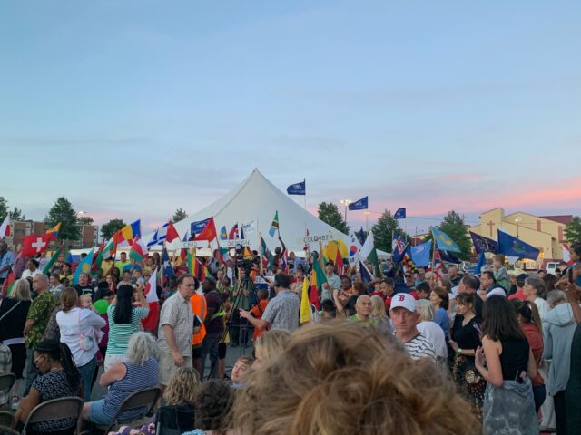 Crowd with international flags at outdoor event.