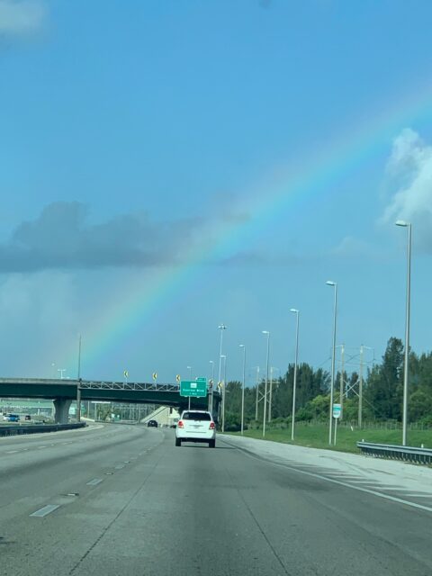 Highway with rainbow in the sky.