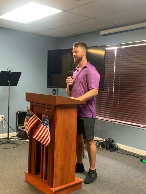 Man speaking at podium with microphone.