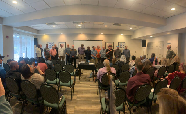 People standing in a meeting room presentation.