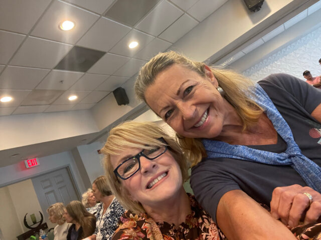 Smiling women taking a selfie indoors.