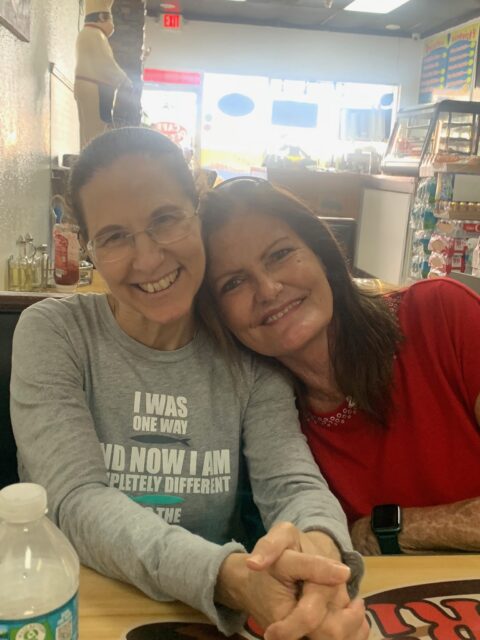 Two women smiling at a restaurant table.