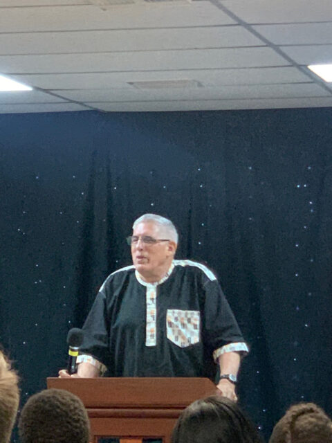 Man speaking at podium with microphone.