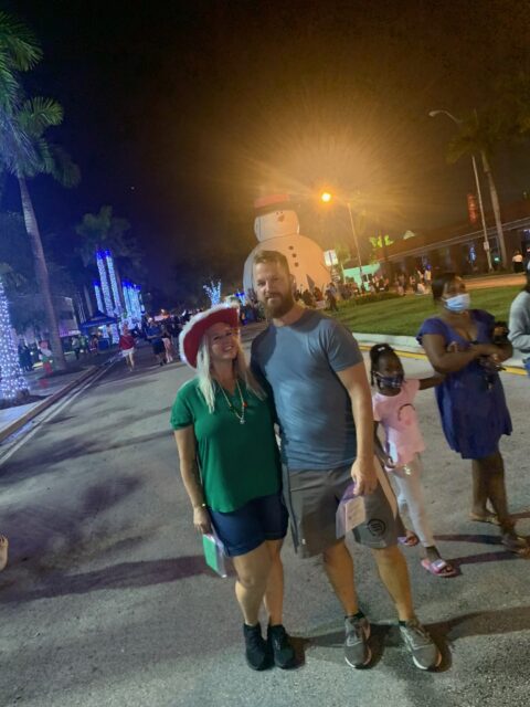 Couple posing at festive outdoor event.