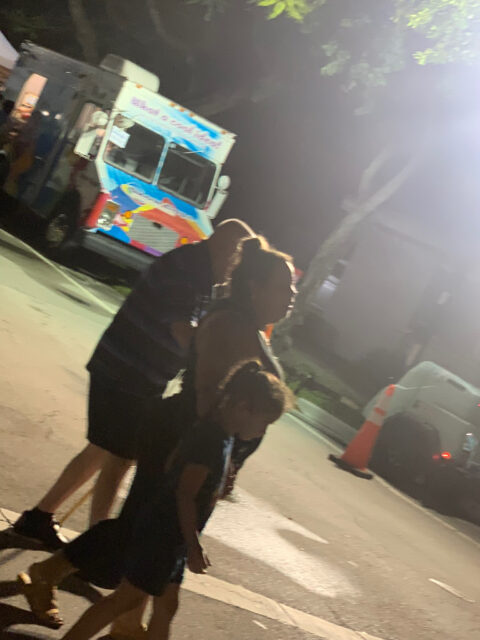 Family walking near ice cream truck at night.