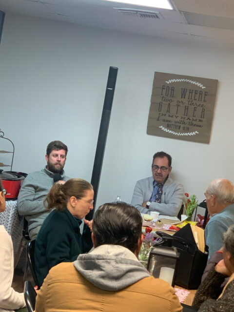 Meeting with people seated around a table.