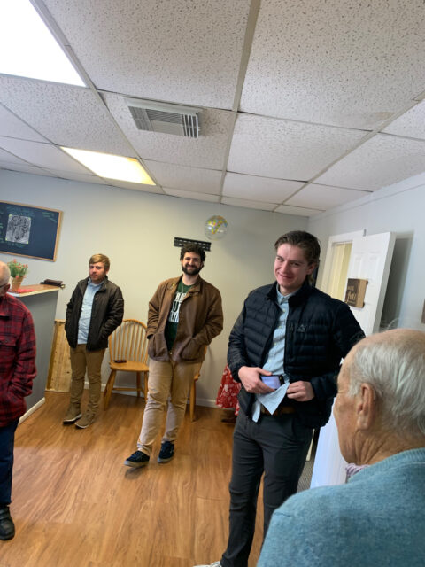 Group of people standing in a room.