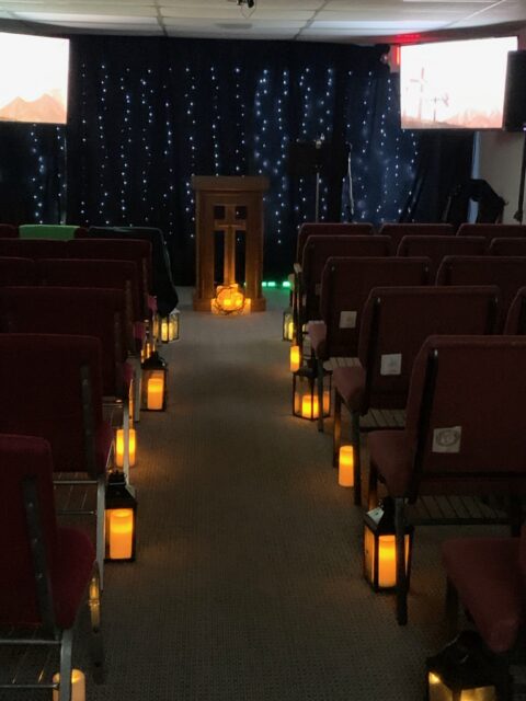 Dimly lit room with chairs and lanterns.