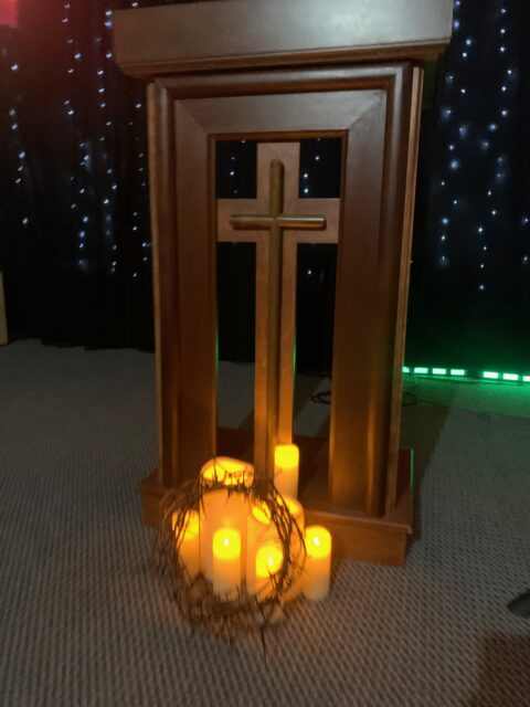 Wooden podium with cross and candles.