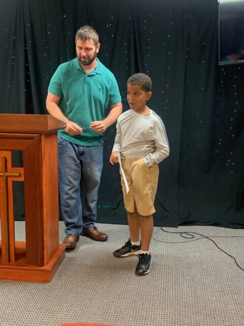 Man and boy standing near podium.