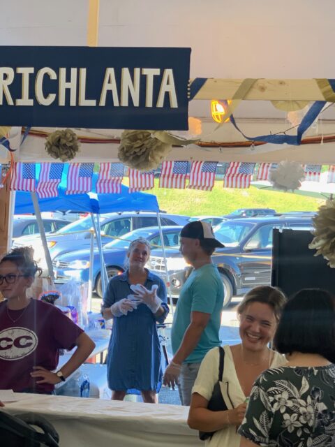 People chatting at a market stall.