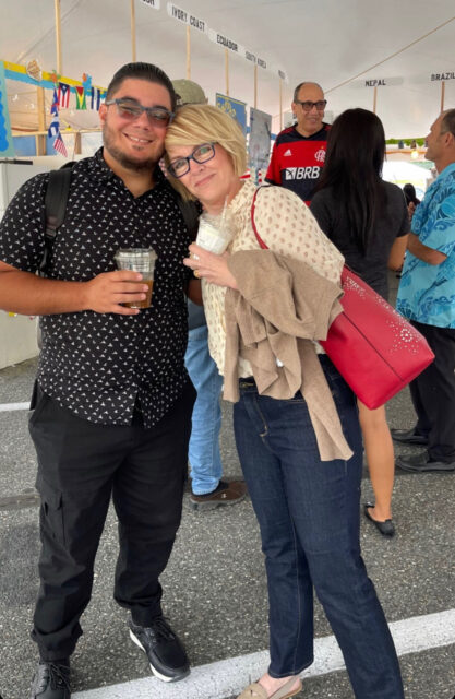 Two people smiling at an outdoor event.