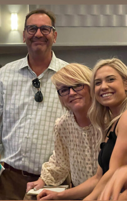 Three people smiling in a group photo.