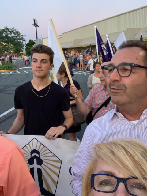 Group holding banners at outdoor event.