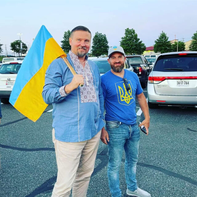 Two men holding a Ukrainian flag.