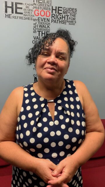 Smiling woman in polka dot dress.